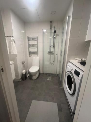 a bathroom with a toilet and a washing machine at Nice flat in Barkarby in Järfälla