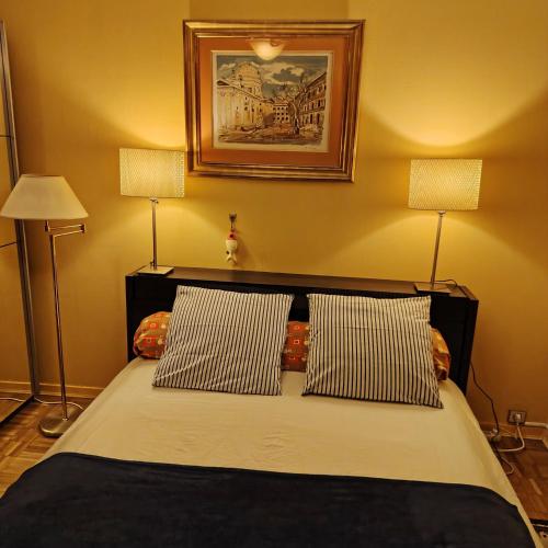 a bedroom with a bed with two lamps and a picture on the wall at "Les Antilles " Héhergement chez l'habitant in Marseille