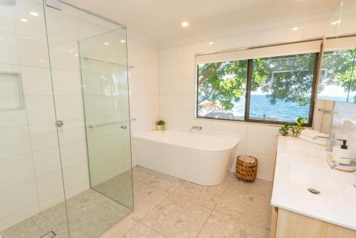 a bathroom with a tub and a glass shower at Amity Treetops - Prime Location - Sleeps 7 in Amity Point