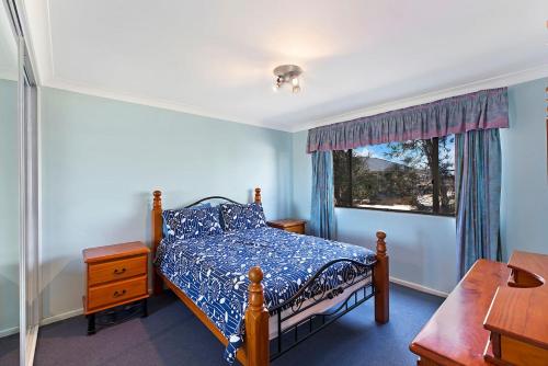 a bedroom with a bed and a window at Pelican Place in The Entrance
