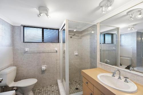 a bathroom with a toilet and a sink and a shower at Pelican Place in The Entrance