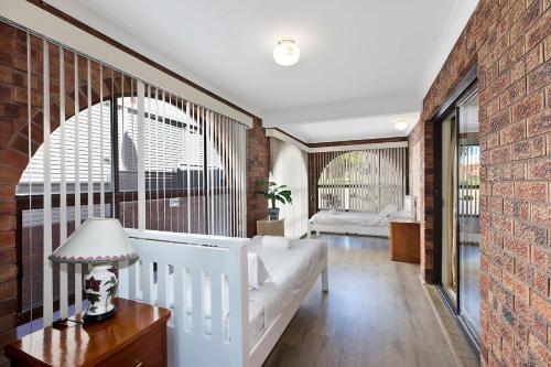 a living room with a white couch and a brick wall at Toukley Waterfront House in Toukley
