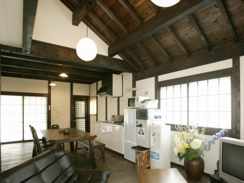 a kitchen and living room with a table and a couch at Nagomiya Hirugano in Gujo