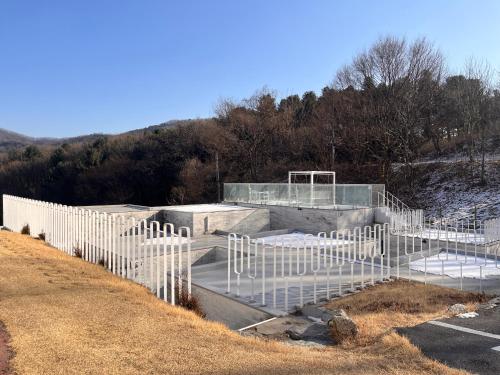 a building with a white fence on a hill at Over The Mountain in Gapyeong