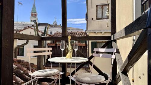 ein Tisch und zwei Stühle auf einem Balkon mit Fenster in der Unterkunft Ca' ai Sospiri in Venedig