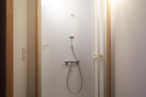 Ein Duschkopf hängt an einer Wand neben einer Tür. in der Unterkunft rento in Sobetsu