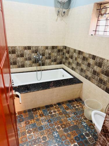 a bathroom with a tub and a toilet at Suites by the Glaswater in Kalyānpur