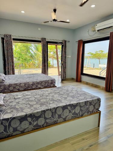 a bedroom with two beds and a large window at Suites by the Glaswater in Kalyānpur