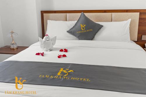 a bed with a hotel sign and red roses on it at Tâm Khang Hotel in Móng Cái