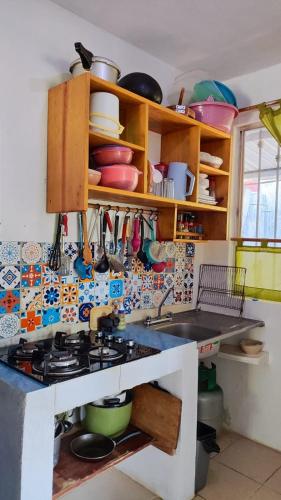 a kitchen with a sink and a stove top oven at La Casita Puerto Arista in Puerto Arista