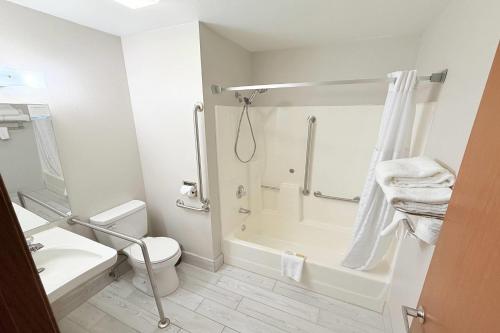 a white bathroom with a toilet and a shower at Super 8 by Wyndham Hot Springs in Hot Springs