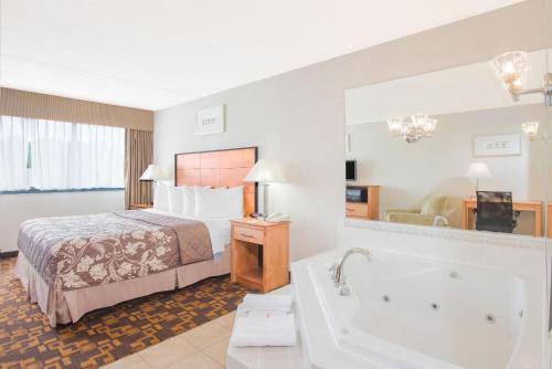 a hotel room with a bed and a bath tub at Days Inn by Wyndham Gettysburg in Gettysburg