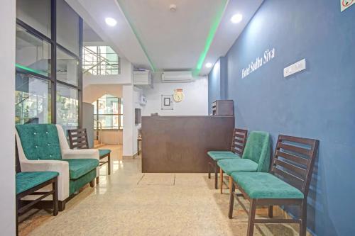 a waiting room with green chairs and a podium at Open Hotel by Olive - Sadha Siva Airport Road, Chennai in Chennai