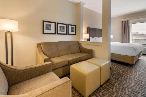 a hotel room with a couch and a bed at Comfort Inn & Suites Pittsburgh-Northshore in Pittsburgh