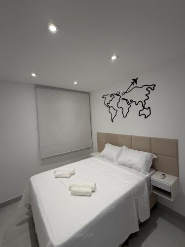 a bedroom with a white bed with two towels on it at Apartamento Novo Infinity in Vila Velha