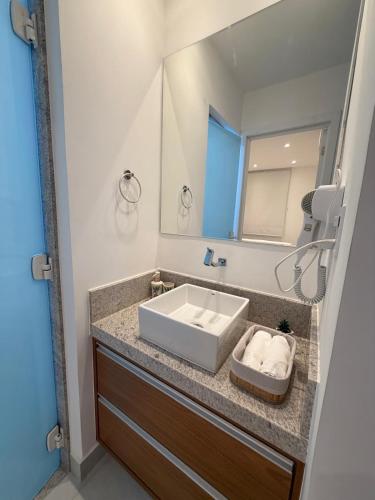 a bathroom with a sink and a mirror at Apartamento Novo Infinity in Vila Velha