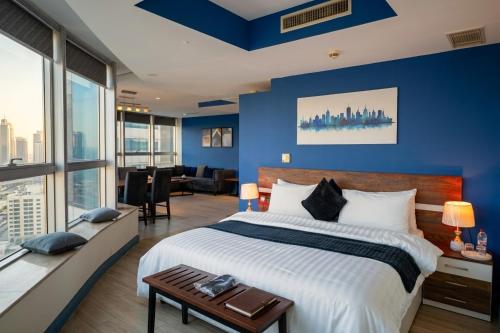 a bedroom with blue walls and a large bed at Walk-Inn Centaurus Hotel Apartments Islamabad in Islamabad