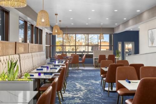 a dining room with tables and chairs and windows at DoubleTree by Hilton Salisbury in Salisbury