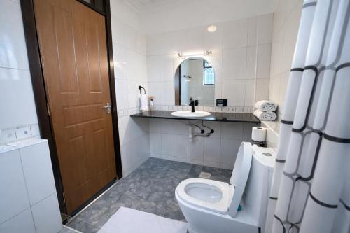 a bathroom with a toilet and a sink at Ary Homestay Nyali At Shikara Apartments 5th Avenue Nyali, Mombasa, Kenya in Mombasa