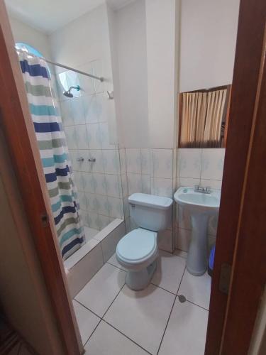 a bathroom with a toilet and a sink at Hallpa Ica in Ica