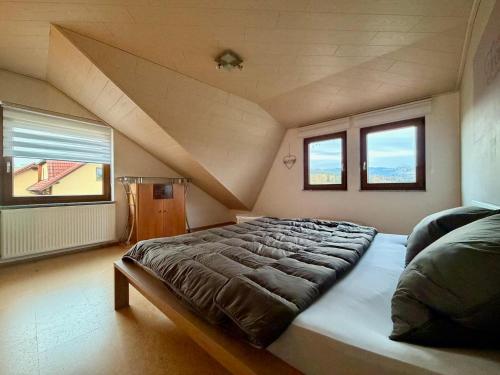 a large bed in a room with two windows at Rauschelbach Loft 9 in Poppenhausen