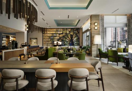 a restaurant with green chairs and tables at Tempo By Hilton Nashville Midtown in Nashville