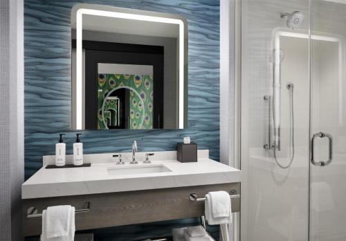 a bathroom with a sink and a mirror at Tempo By Hilton Nashville Midtown in Nashville