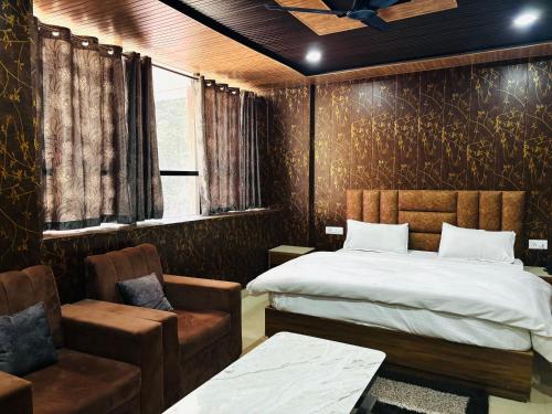 a bedroom with a bed and a couch and a chair at JB Hotel and Resort in Lohaghāt