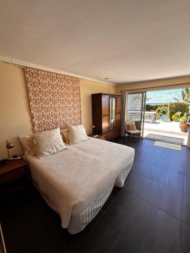 a bedroom with a large bed and a large window at Ocean Escape Resort & Spa in Rarotonga