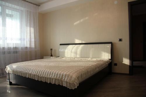 a bedroom with a large bed with a large window at Apartment on Komsomolskaya 295 in Yuzhno-Sakhalinsk