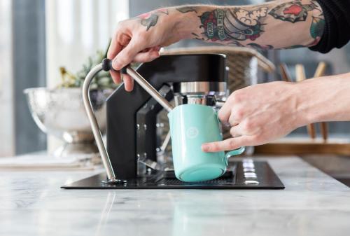 a person is stirring a coffee pot on a counter at Leman Locke in London