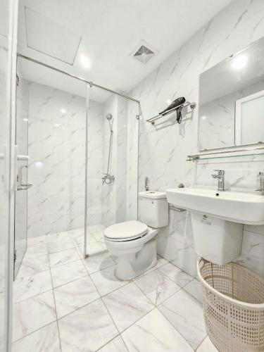 a white bathroom with a toilet and a sink at Lakenest 06 - Quiet Place in Hanoi
