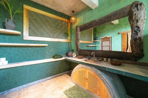 a bathroom with a sink and a mirror at Highlife Hill Villa in General Luna