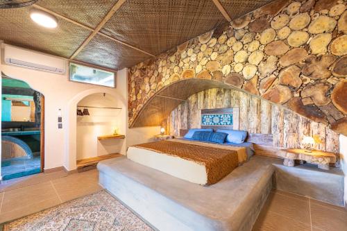a bedroom with a bed and a stone wall at Highlife Hill Villa in General Luna