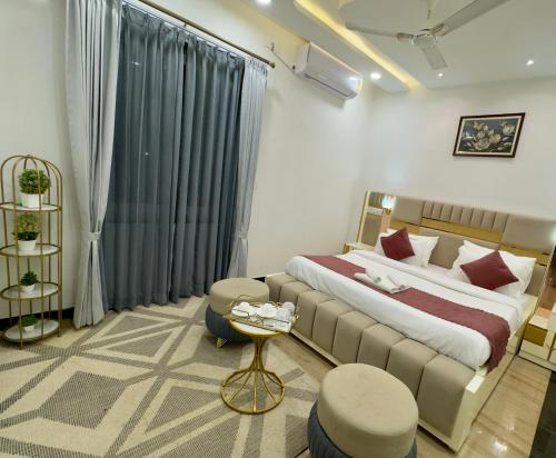 a bedroom with a bed and a couch and a table at Sagar Villa Udaipur in Udaipur