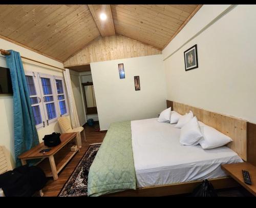 a bedroom with a bed and a wooden ceiling at Shivay Hotel & Resort in Dhārchula
