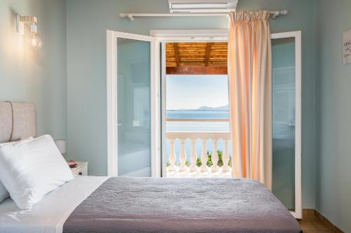 a bedroom with a bed and a view of the ocean at Baracunda Seaview Apartments with private Hot Tub by Konnect in Barbati