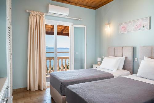 a bedroom with two beds and a view of the ocean at Baracunda Seaview Apartments with private Hot Tub by Konnect in Barbati