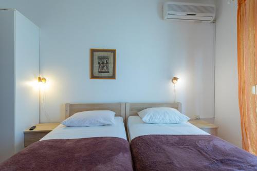 two twin beds in a room with two lamps at Tinka, Zimmer No 10 in Starigrad