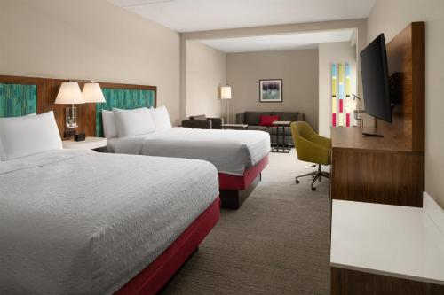 a hotel room with two beds and a living room at Hampton Inn Spring Lake Fayetteville in Spring Lake