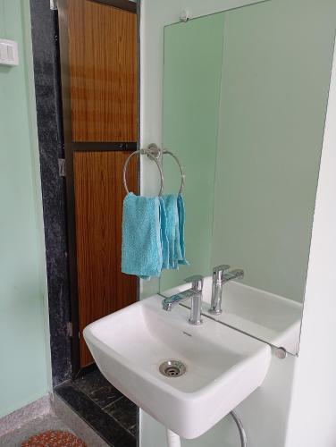 a bathroom with a white sink and a mirror at Satvik Homestay in Devgarh