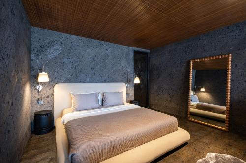 a bedroom with a bed and a mirror at The Lima Ocean Suites Pererenan in Canggu