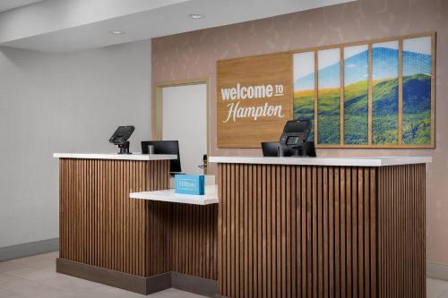 a lobby with a welcome to hamburg sign on the wall at Hampton Inn & Suites Clinton in Clinton