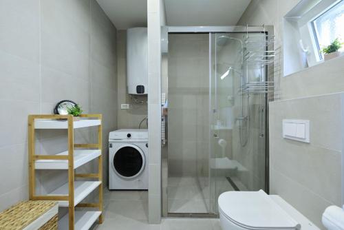 a bathroom with a shower and a washing machine at Holiday house Luca with private pool in Vrsi