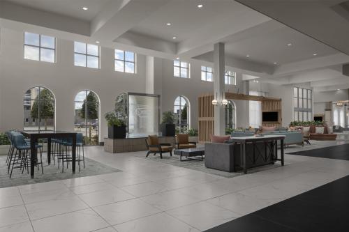 a lobby with tables and chairs in a building at Embassy Suites by Hilton Tuscaloosa Alabama Downtown in Tuscaloosa