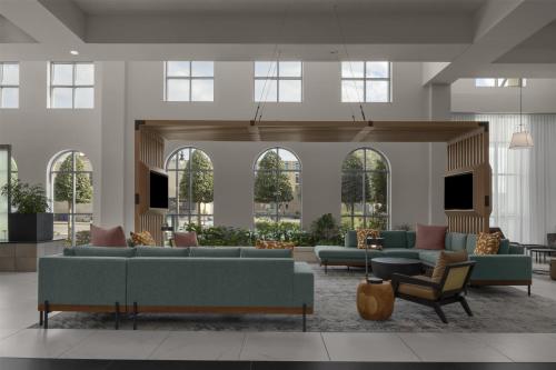 a lobby with couches and chairs and windows at Embassy Suites by Hilton Tuscaloosa Alabama Downtown in Tuscaloosa