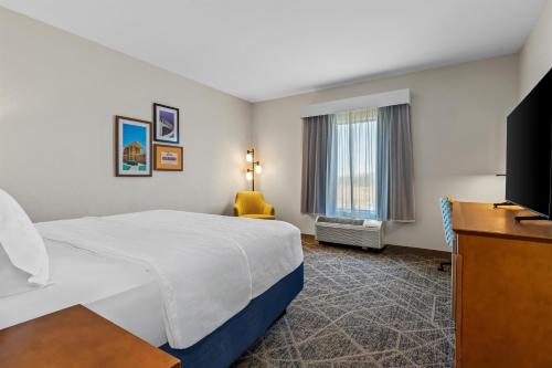 a hotel room with a bed and a flat screen tv at Hampton Inn & Suites Claremore in Claremore