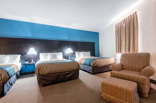 a hotel room with two beds and a chair at Econo Lodge in Sudbury