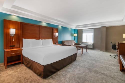 a hotel room with a large bed and a desk at Comfort Inn Manchester Airport in Manchester