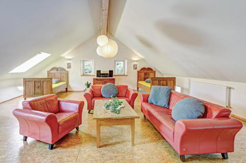 a living room with red couches and blue pillows at Nengshof Ferienhaus Königskerze in Wißmannsdorf